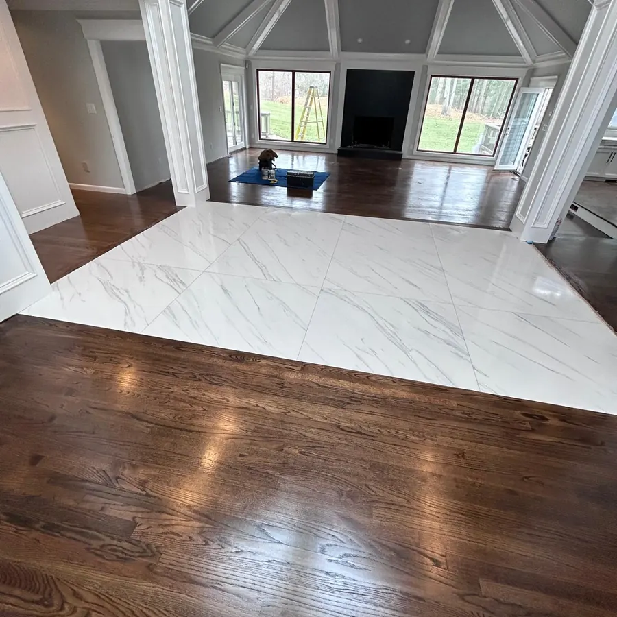 Hardwood floor meeting a marble look tile floor at a clean transition