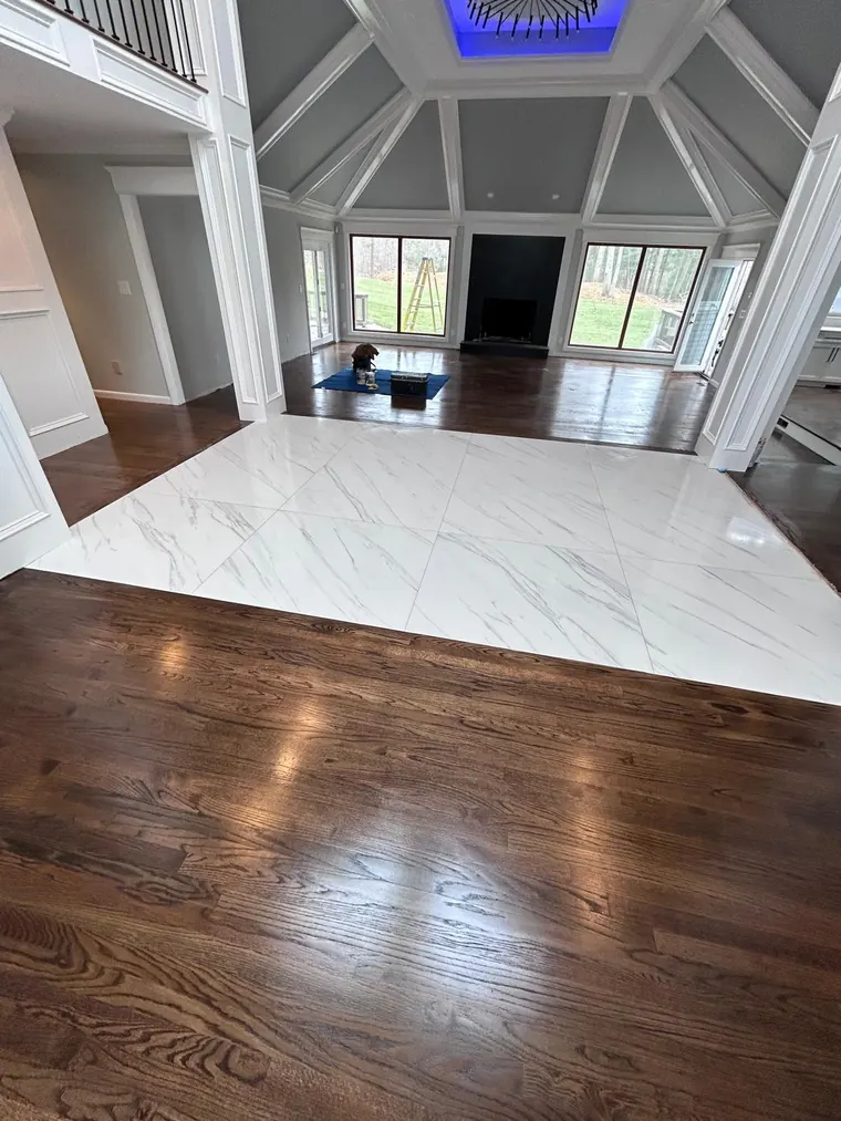 Hardwood floor meeting a marble look tile floor at a clean transition