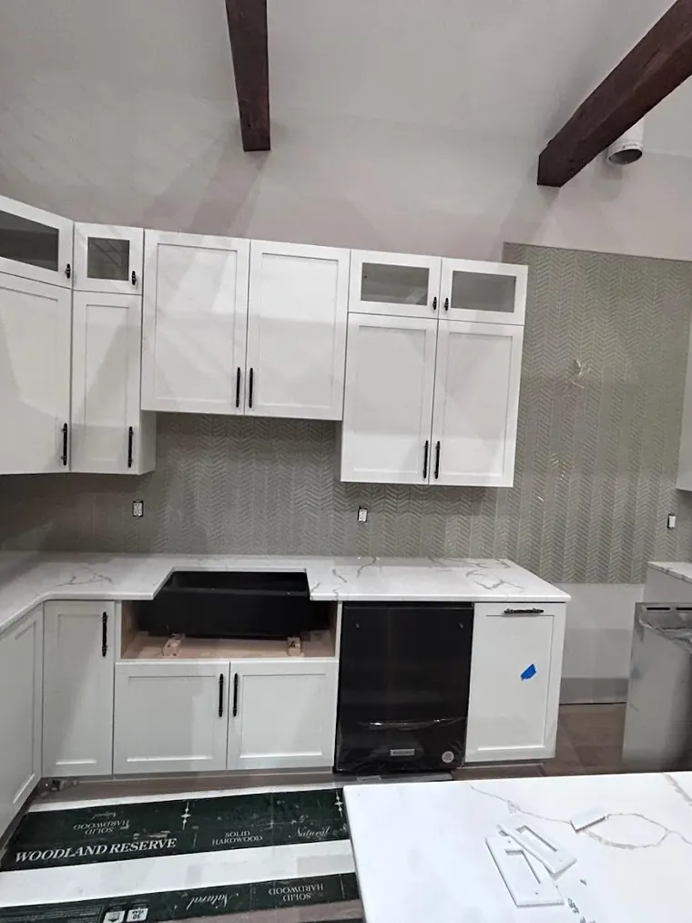 White kitchen cabinets and quartz counters during installation